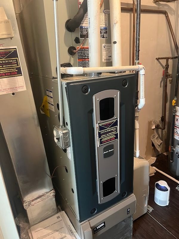 Furnace cabinet with a visible City & Suburban service sticker