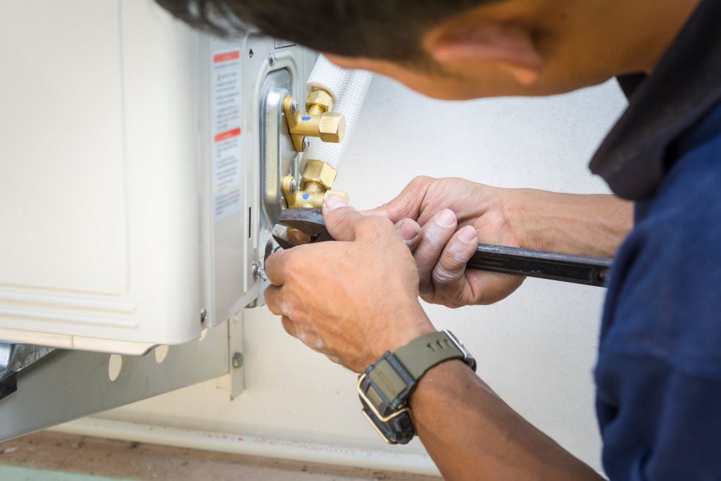 Air conditioning repair technician working on a unit